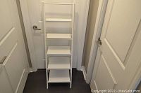 Front view of the white wooden ladder-style shelf showing all five shelves and angled side supports.