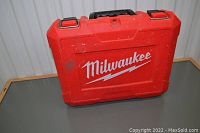 Closed red hard plastic Milwaukee carrying case with metal clasps