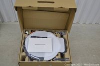 Opened cardboard box showing vacuum wrapped in protective foam and accessories in molded inserts