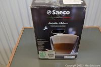 Original box front showing Saeco Intelia Deluxe logo and coffee cup image