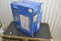 Blue cardboard box showing Midea brand, product image of the white dehumidifier, and French product information.