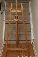 Front view of the wooden artist easel showing its full height and tripod structure