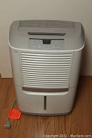 Front view of Frigidaire dehumidifier showing full body, power cord, bucket compartment and vents.