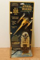 Front view of unopened blister pack showing Naboo Fighter model rocket and launch controller featuring R2-D2 design, plus branding and flight height details on packaging.