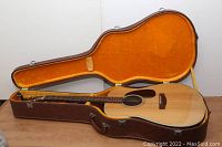 Suzuki guitar seated in its fitted hard shell case showing top and fretboard