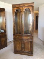 Full view of tall wooden hutch with glass insert doors, drawer, and lower cabinet doors.