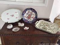 Full collection shown on wooden cabinet including plates and porcelain figurines