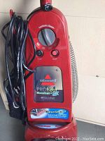 Front of the red Bissell PROheat Cleanshot carpet cleaner showing control dial and logo.