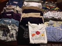 Full view of blouses and pants folded and laid out showing patterns, colors, and fabrics.