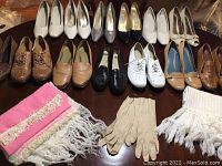 Photo showing 12 pairs of women's shoes in various styles and colors including brown, black, beige, white, and silver, plus scarves and gloves.