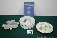 Lot contents showing the boxed set of plates, the shamrock wall hanging, and the Irish book 'Ouzel Galley'