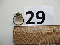 Side profile of ring with measuring ruler showing width and numbered card
