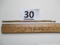 Bracelet laid next to ruler showing 8in length and overall braid design