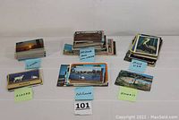 Image of grouped and stacked postcard collections labeled for Alaska, California, Hawaii, Arizona, and mixed USA states