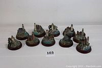 Photo of all 10 miniature lighthouses arranged in two rows, showing the different styles and bases.