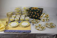 Full display of the ceramic dinnerware service, textiles, and decorative pieces arranged on table