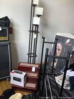 Wide view showing floor lamp, dog stairs, hats on floor, and packaged queen sheet set on stairs