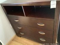 Front view of dresser showing three drawers and two open cubbies on top.