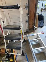 Cosco 3-step step stool front view showing black anti-slip treads and white frame with signs of usage.