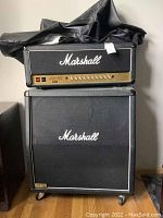 Front view of amplifier head stacked on angled speaker cabinet