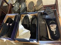 Image showing three pairs of men's dress shoes and two pairs of flip flops in shoeboxes and on table.