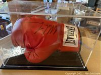 Side view of red Everlast glove with Mike Tyson signature inside clear display case