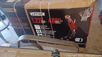 Sealed cardboard box labeled Lifetime with image of assembled basketball system
