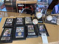 Overview of eight framed cards and three baseballs on table