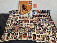 Display of assorted basketball trading cards arranged on a flat surface with a Dwayne Wade notebook centered behind them.