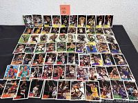 Photo showing a spread of basketball trading cards arranged in rows featuring various players from the 90s NBA.