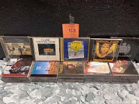 Photo of two rows of music CDs featuring titles such as Gilt, Classic Country Music compilation, Curves for Women Taking It All, and other assorted CDs.