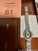 Full view of the watch laid out with brown Tempo Viso gift box in background along with auction tag and warranty card visible underneath.