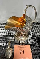 Full view of silver-plated sugar scuttle accompanied by matching scoop on display surface
