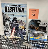 Lot overview photo showing graphic novel with Star Wars Rebellion cover, Hot Wheels Poe's X-Wing Fighter in package, and metal keyring.