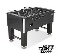 Oblique front view of black foosball table showing tempered glass playing surface, tournament men, and drink holders