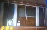 Overall view of the white vinyl picture window installed against a plywood backing, framed with string lines