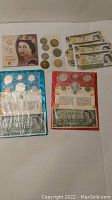 Overall lot showing two proof-like sets in packaging, loose bills, coins, and keepsake booklet