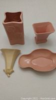 Four Abingdon pottery artware items including two vases, a tray, and a wall sconce shown from a top-down view to capture size and shape.