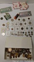 Full lot overview showing all coins, rolls, banknotes, and miscellaneous pieces in a box