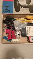 Box containing controllers, wiring, parts, and instruction manual for Strombecker race car set.