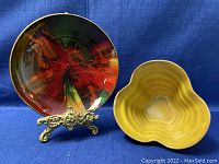 Photo of the Seetusee art glass plate with swirling colors and the yellow Canadian pottery bowl side by side on a blue cloth background.