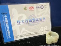 Certificate showing authenticity of the jade ring from a gem testing center with official logos and text in Chinese.