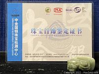 Photo of the Certificate of Gems & Jewelry Identification with official logos and Chinese text, verifying the authenticity of the jade jewelry.
