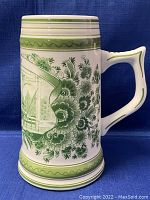 Front view of Delft green hand painted beer stein showing floral design and detailed scene panel.