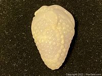 Front view showing the carved details of the grape cluster on translucent white jade with visible grape textures and leaf design.