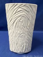 Front view of textured off-white bisque vase with abstract raised pattern