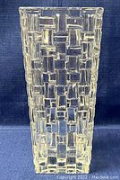Frontal photo showing clear crystal basket-weave patterned vase standing upright.