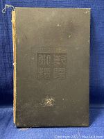 Front side of one wooden book cover with carved Chinese characters and decorative seal