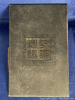 Front view of the old wooden book cover showing carved Chinese characters inside a geometric border.