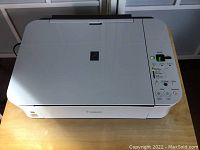 Front and top view of Canon PIXMA MP240 printer showing clean surface, control panel with buttons and status lights.